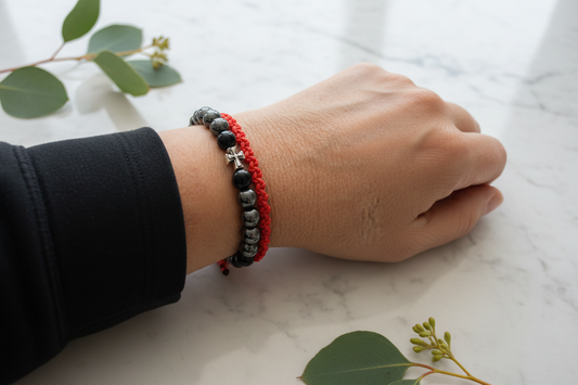 Black Agate with Cross and Red Macrame on wrist with elegant background