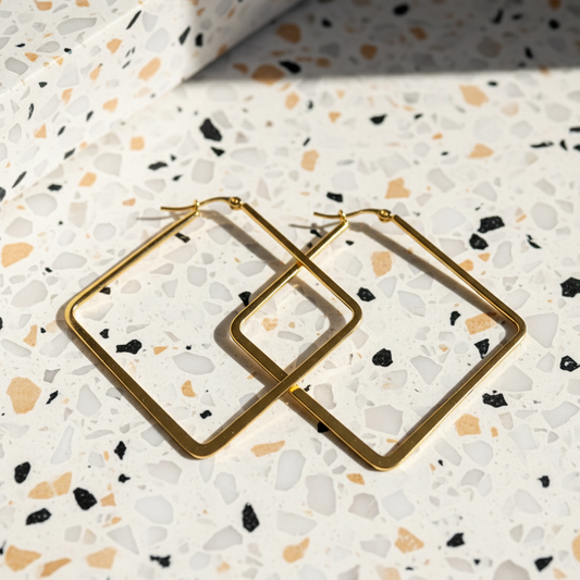 Gold square hoops on terrazzo