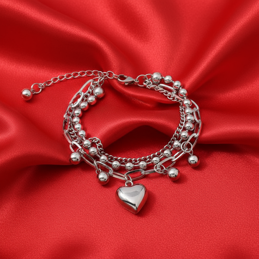 Heart charm bracelet on bright red satin background