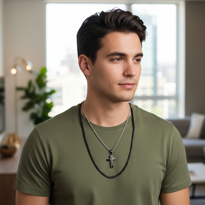 Male model wearing layered necklace set with bicolor cross